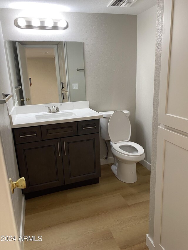 bathroom featuring hardwood / wood-style floors, vanity, and toilet