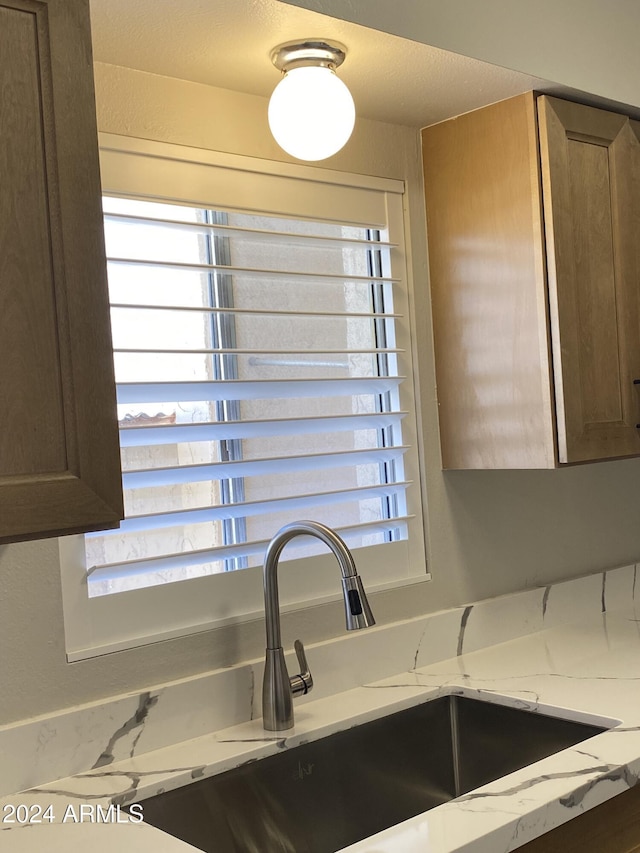 room details featuring light stone counters and sink