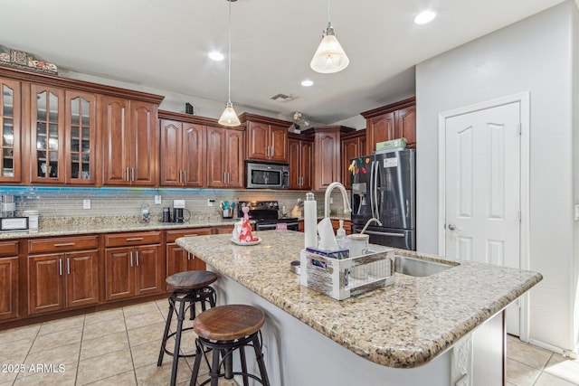 kitchen with a breakfast bar area, light tile patterned flooring, visible vents, appliances with stainless steel finishes, and backsplash