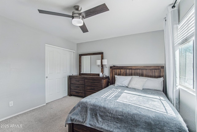 carpeted bedroom with ceiling fan and baseboards