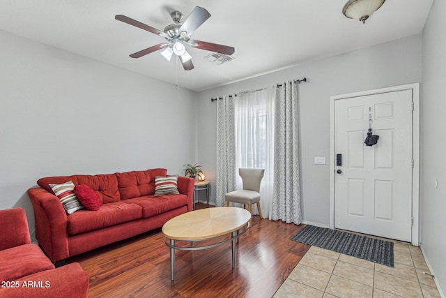 living area with ceiling fan, visible vents, light wood-style flooring, and baseboards