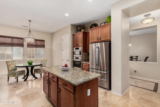 2554 E Honeysuckle Pl, Chandler, AZ 85286 - kitchen featuring stainless steel appliances, a kitchen island, light stone countertops, decorative light fixtures, and recessed lighting