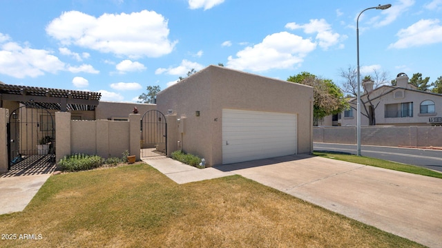 3345 E University Dr Unit 47, Mesa, AZ 85213 - view of front of property with a gate, concrete driveway, stucco siding, and a garage