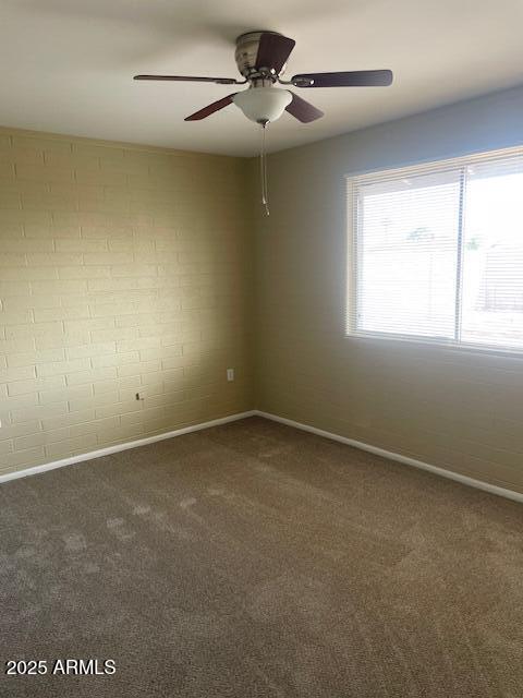 carpeted spare room featuring ceiling fan