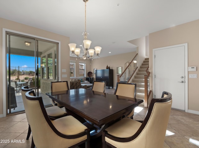 dining space with a chandelier, stairway, baseboards, and light tile patterned floors