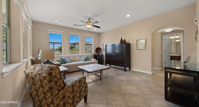 living area with arched walkways, ceiling fan, baseboards, recessed lighting, and light tile patterned floors