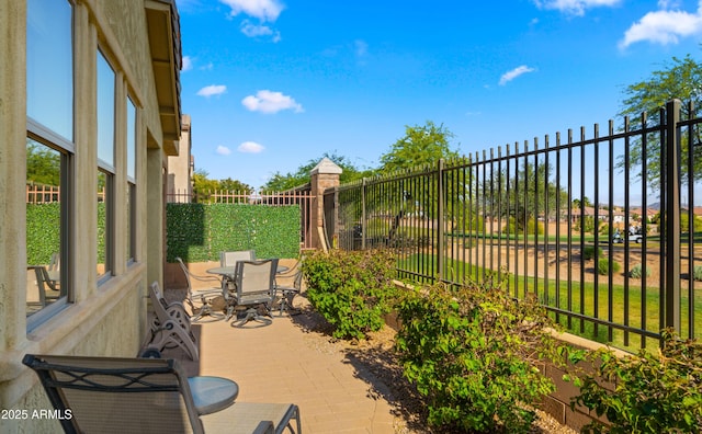 view of patio with outdoor dining area and fence