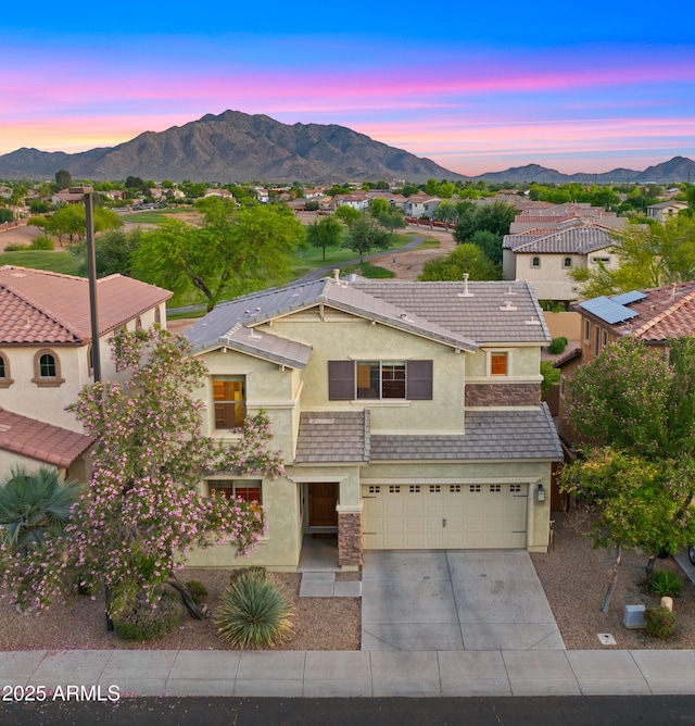 view of front of home featuring stucco siding, a mountain view, concrete driveway, and a garage