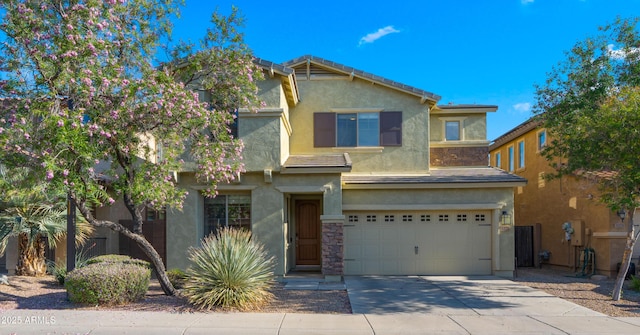 traditional-style home with a garage, stucco siding, concrete driveway, and a tile roof