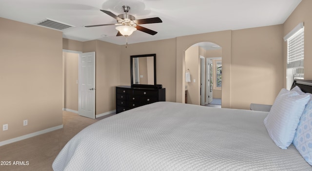 carpeted bedroom with arched walkways, baseboards, and ceiling fan