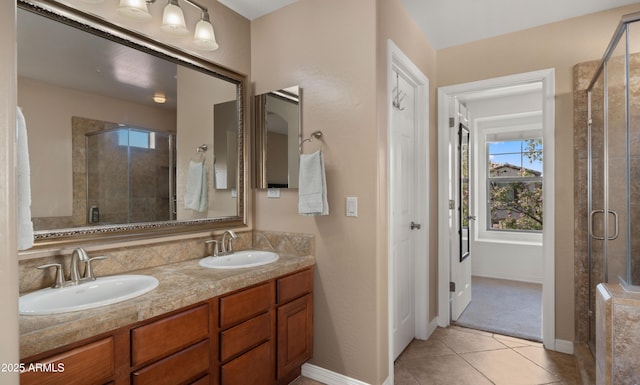 bathroom with a stall shower, tile patterned flooring, double vanity, and baseboards