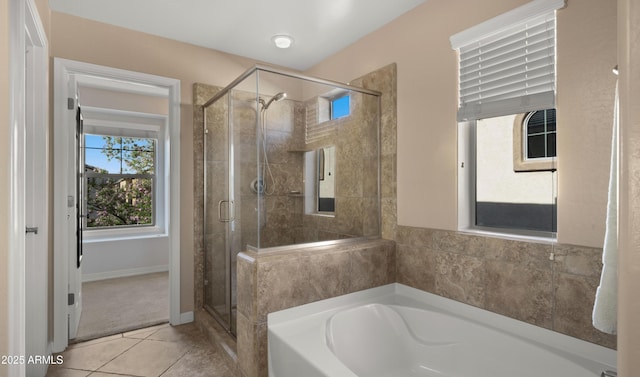 full bathroom featuring a stall shower, a bath, and tile patterned flooring