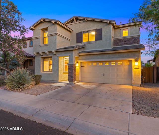 view of front of property featuring stucco siding, a garage, driveway, and fence