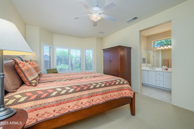19607 N Flint Way, Surprise, AZ 85374 - bedroom with multiple windows, light carpet, connected bathroom, and ceiling fan