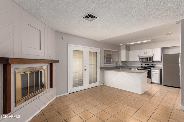 kitchen featuring white cabinets, kitchen peninsula, stainless steel appliances, french doors, and sink