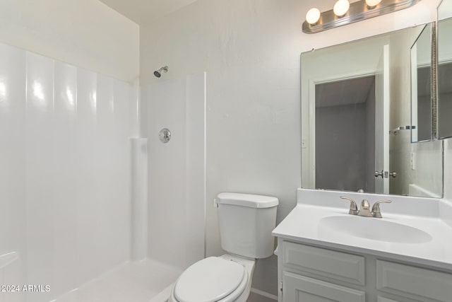 bathroom featuring walk in shower, vanity, and toilet