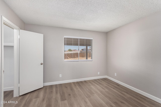 unfurnished bedroom featuring a textured ceiling and light hardwood / wood-style flooring