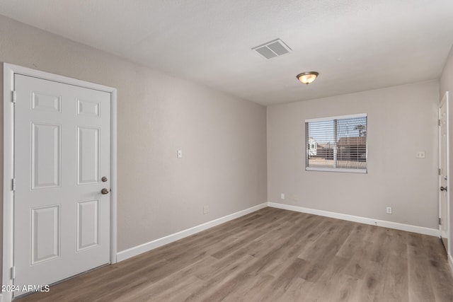 unfurnished room with light wood-type flooring