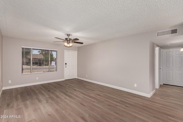 empty room with wood-type flooring, a textured ceiling, and ceiling fan