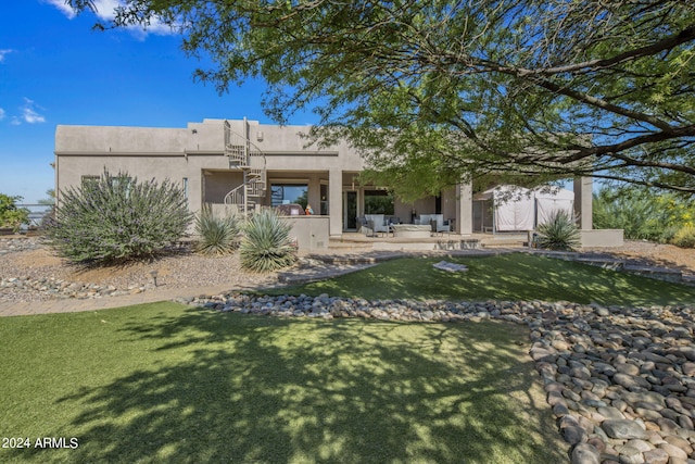 back of house with a patio area and a lawn