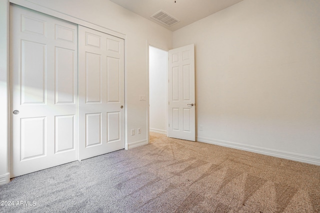 unfurnished bedroom featuring carpet and a closet