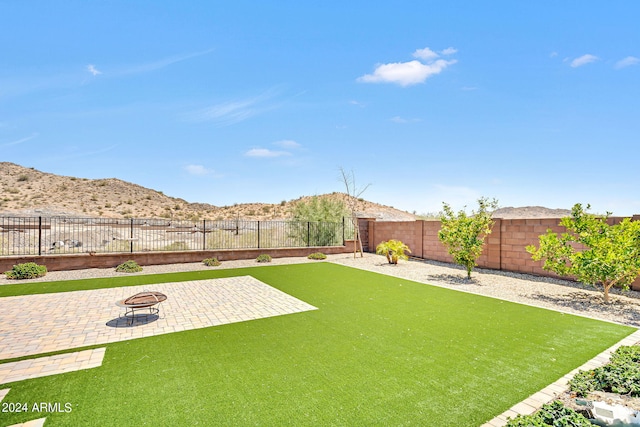 view of yard with a mountain view, a patio, and an outdoor fire pit