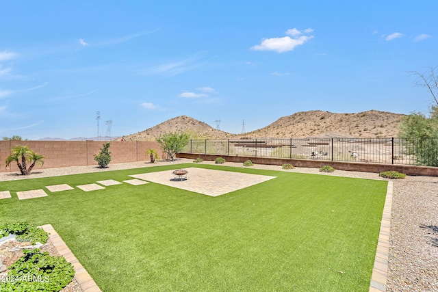 view of yard with a mountain view and an outdoor fire pit