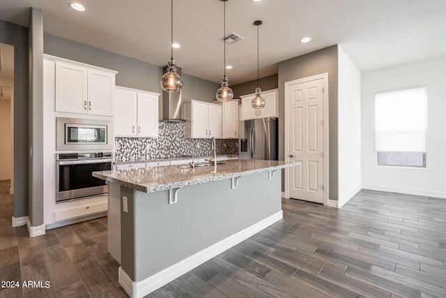 kitchen with white cabinetry, a center island with sink, and appliances with stainless steel finishes