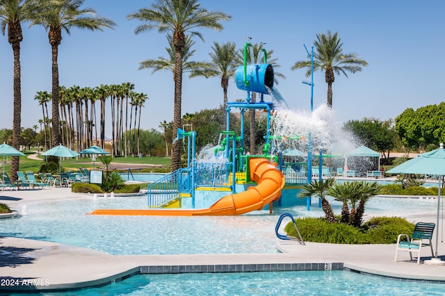 view of swimming pool featuring a playground and a water slide