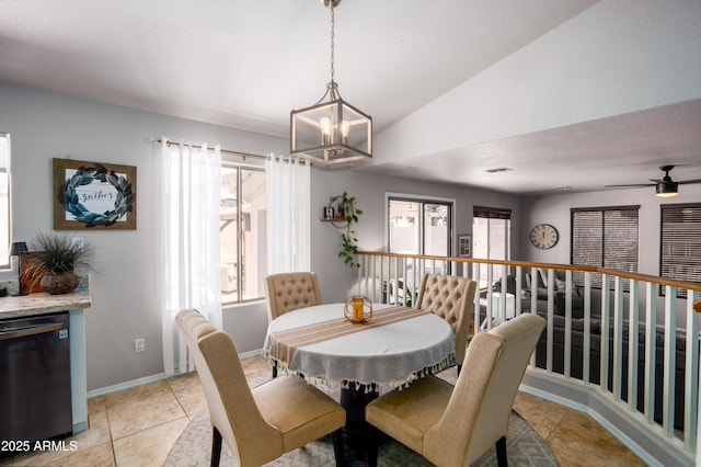 dining room with baseboards, ceiling fan with notable chandelier, light tile patterned flooring, and lofted ceiling