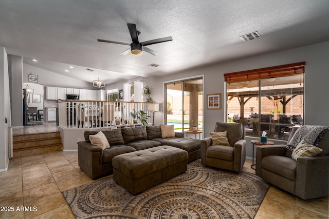 living area with light tile patterned floors, ceiling fan, a textured ceiling, and visible vents