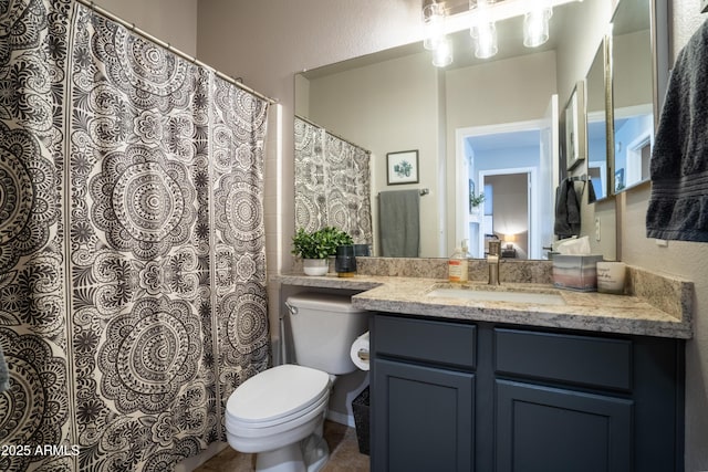 bathroom with toilet, a textured wall, and vanity