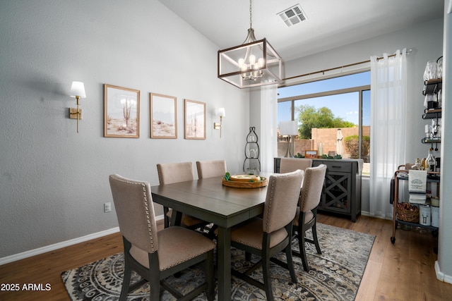 dining room featuring baseboards, visible vents, an inviting chandelier, and light wood-style floors