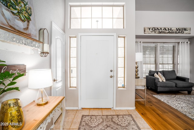 foyer with light tile patterned flooring, a high ceiling, and a wealth of natural light
