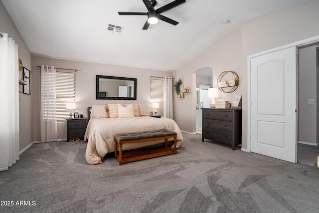 carpeted bedroom with arched walkways, baseboards, visible vents, and lofted ceiling