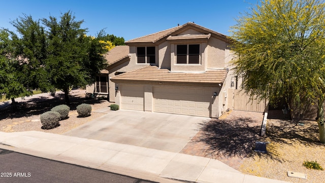 view of front of house with a garage, stucco siding, concrete driveway, and a tiled roof