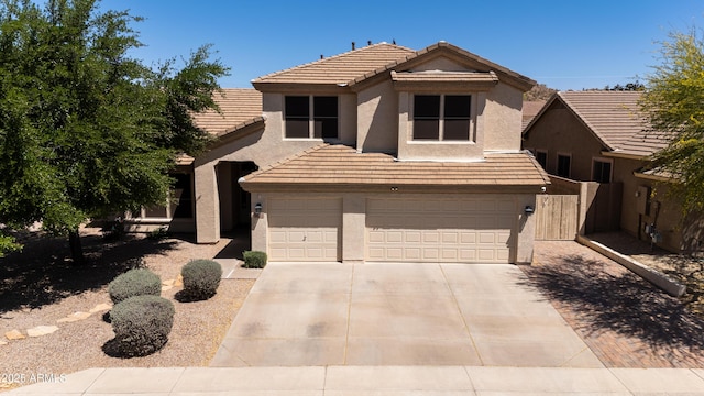 view of front of property with an attached garage, stucco siding, a tiled roof, and concrete driveway