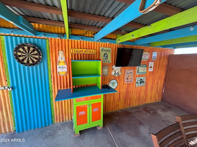 game room with beam ceiling and wooden walls