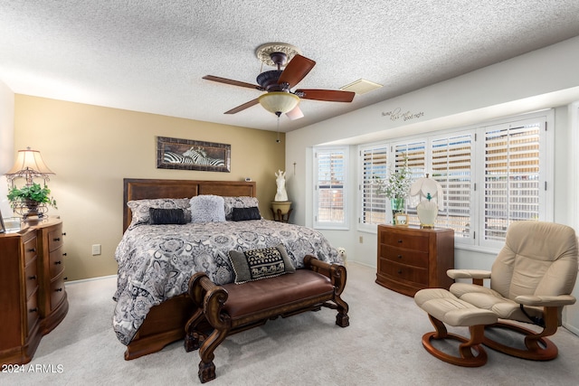 carpeted bedroom featuring a textured ceiling and ceiling fan