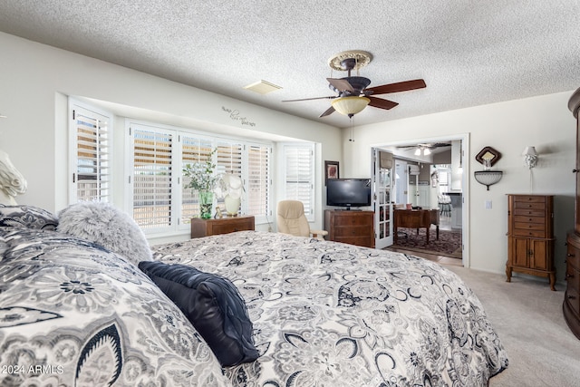 bedroom with a textured ceiling, carpet floors, and ceiling fan