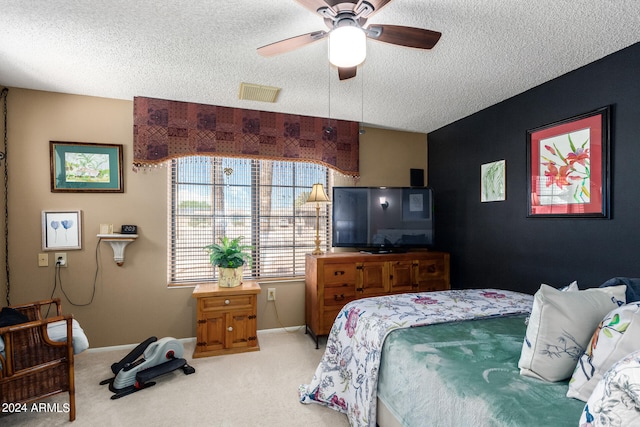 bedroom with ceiling fan, carpet, and a textured ceiling