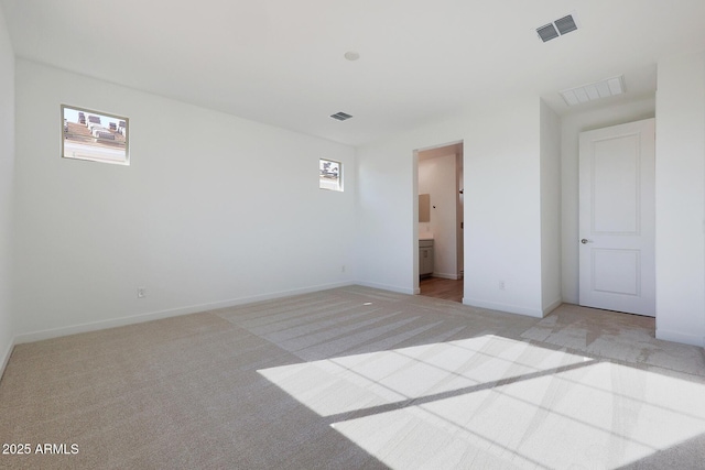 unfurnished bedroom with light carpet and ensuite bath