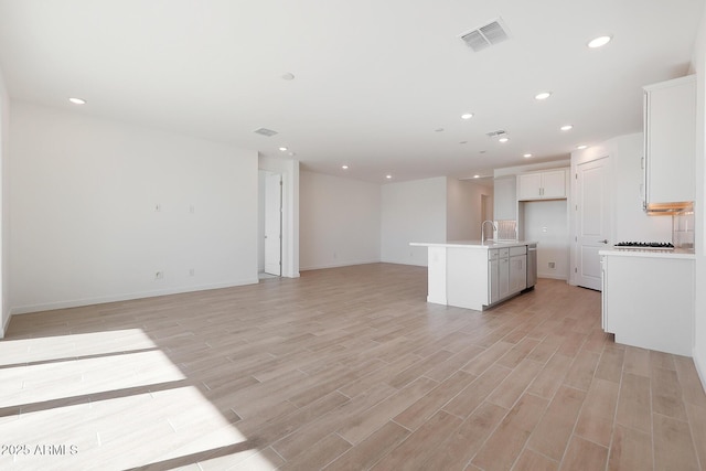 unfurnished living room with sink and light hardwood / wood-style floors