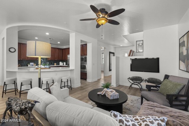 living room featuring ceiling fan and light wood-type flooring