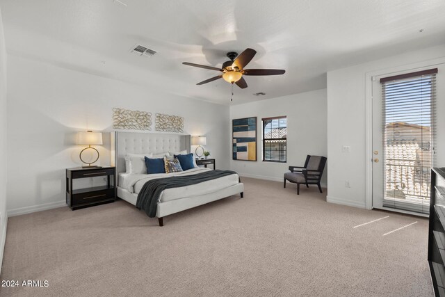 bedroom with multiple windows, access to outside, light carpet, and ceiling fan