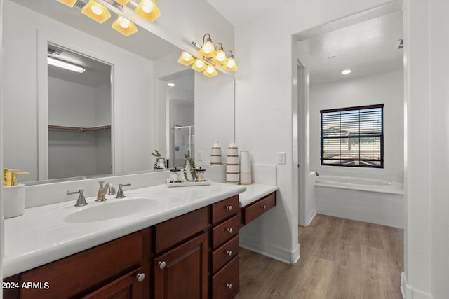 bathroom with vanity, hardwood / wood-style floors, and separate shower and tub