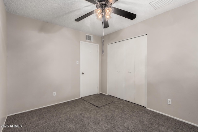 unfurnished bedroom featuring a closet, visible vents, carpet floors, and a textured ceiling