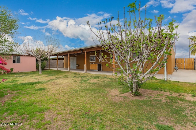 back of property with a patio area, a lawn, and fence