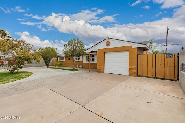 ranch-style house featuring a gate, fence, driveway, an attached garage, and stone siding