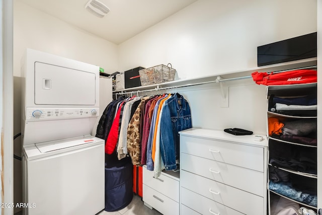 walk in closet with stacked washer and dryer and visible vents